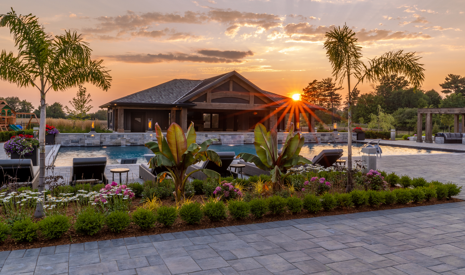 Manicured luxury garden path leading to an estate home at dusk