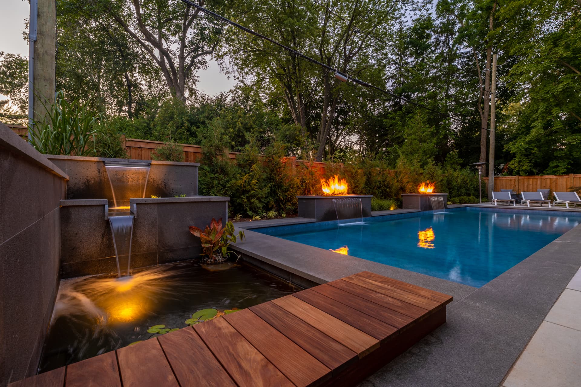 Pool with fire bowls, scupper walls and a koi pond